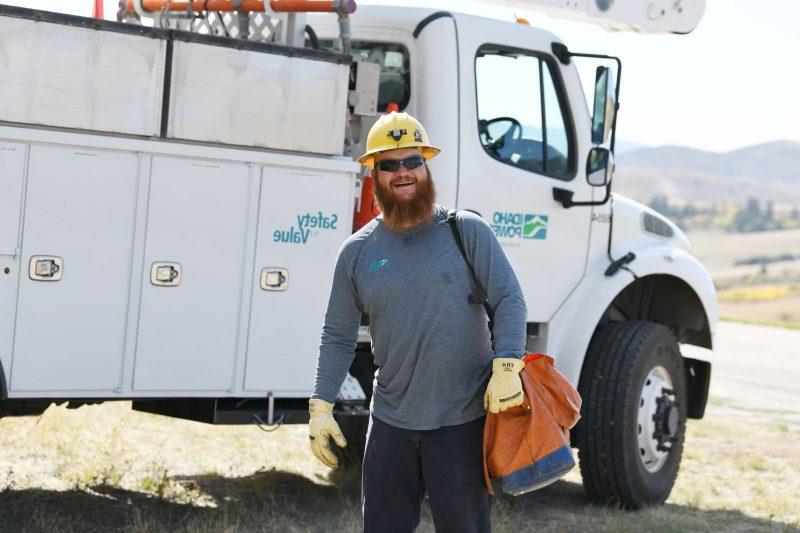 Image of a line crew worker in front of an Idaho Power bucket truck.